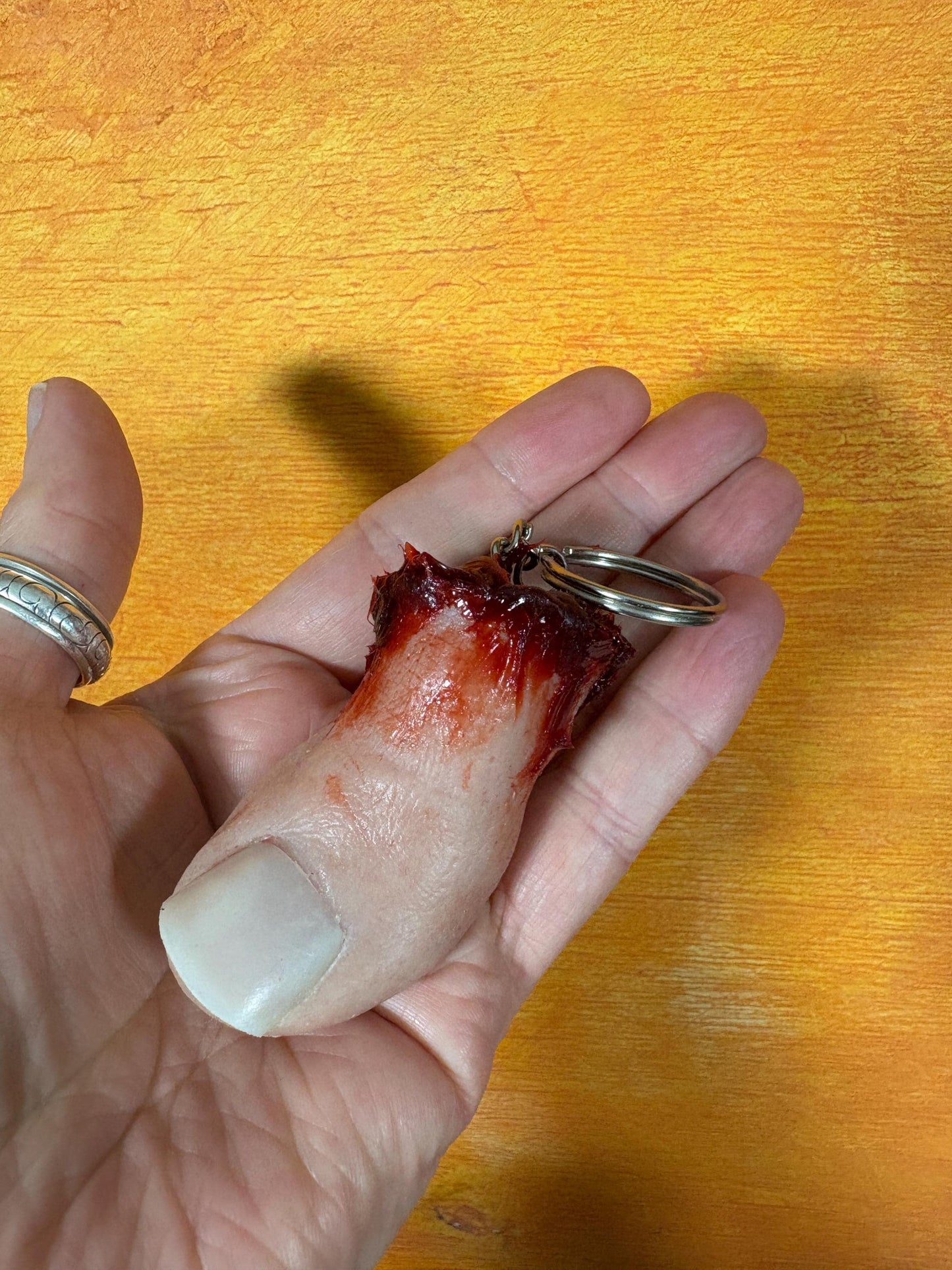 A severed toe keychain with a bloody, gruesome end.