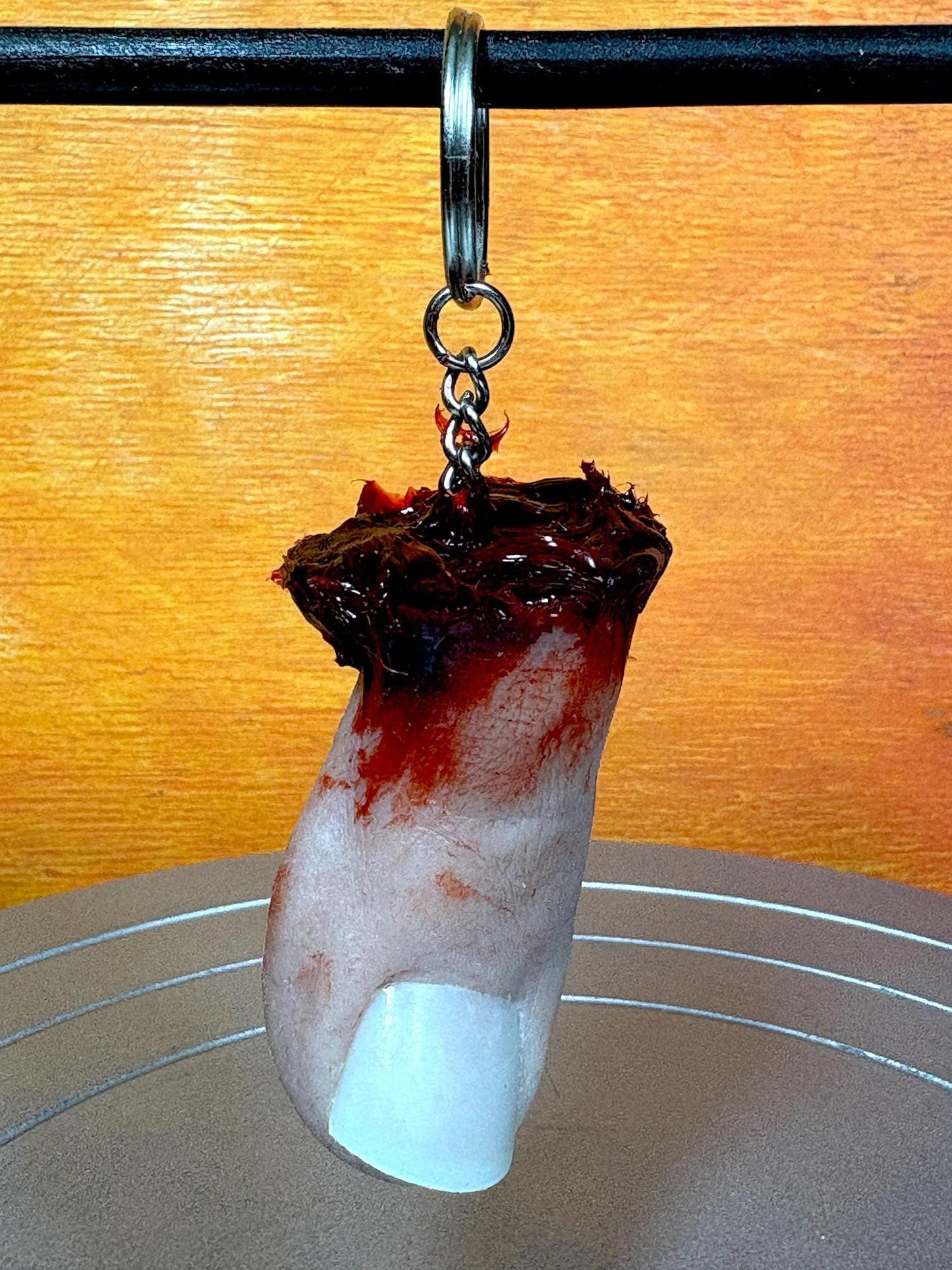 A novelty keychain shaped like a severed toe with a bloody wound.