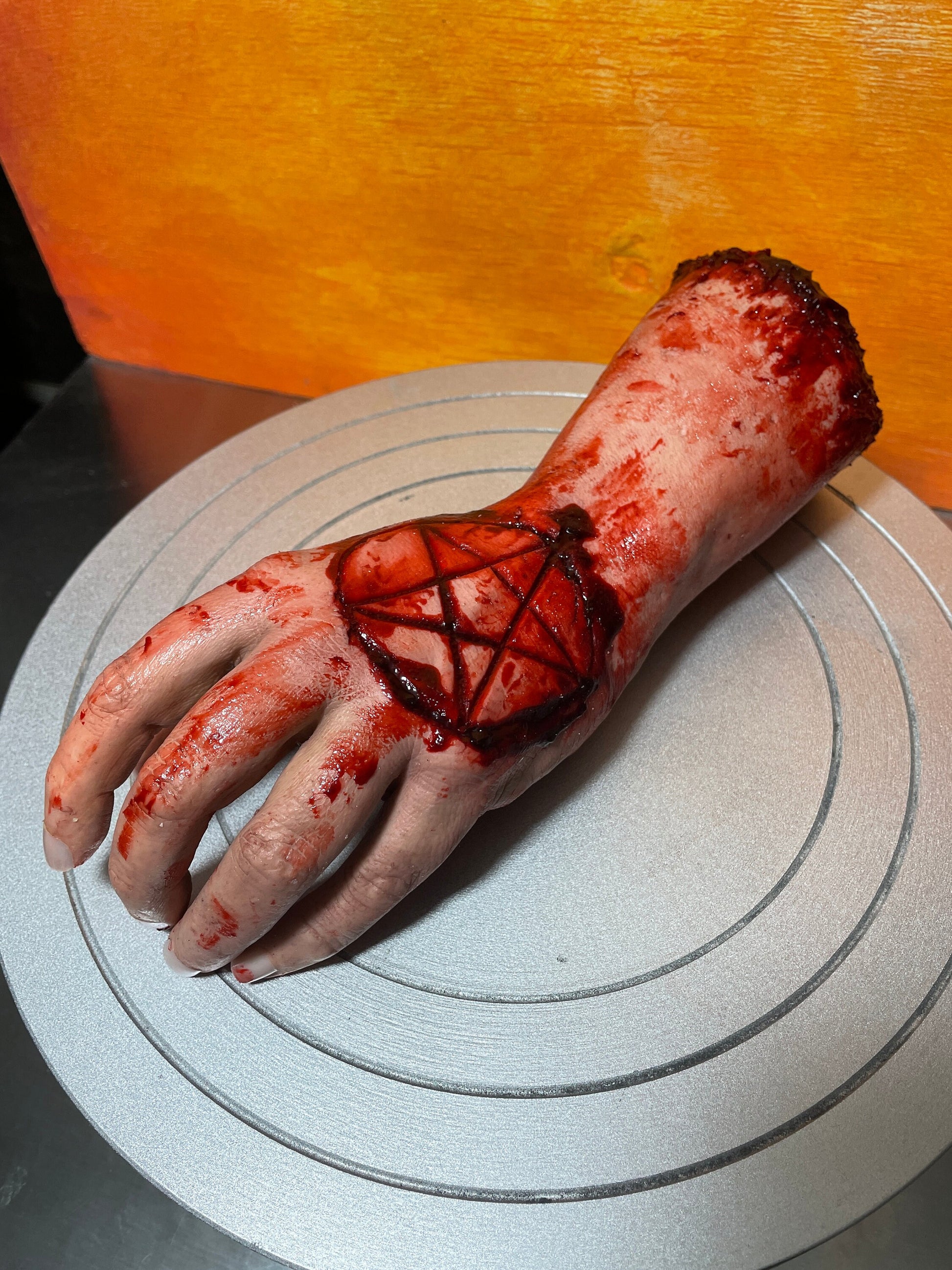 Bloody severed realistic hand with pentagram. Great for Halloween decoration, haunted house or horror prop