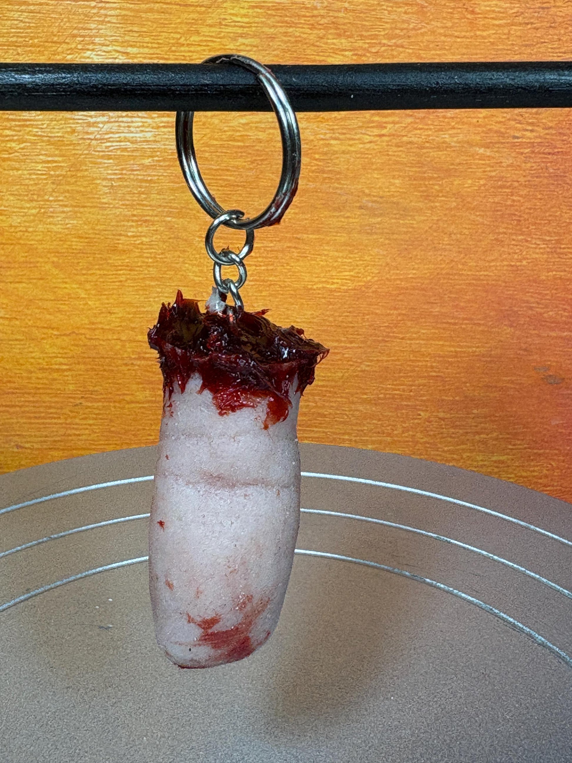 A gruesome keychain resembling a severed, bloody finger.
