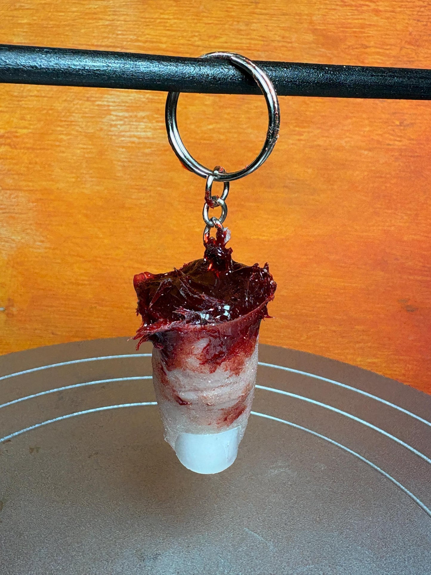 A keychain featuring a gruesome, blood-splattered, finger-shaped charm.